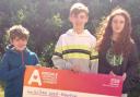 William Wood-Robertson and his siblings with a cheque for the charity