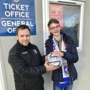 Guiseley AFC Football Secretary and General Manager James Pickles (left) presents a signed match ball to Jamie White who is raising funds to attend the 25th World Scout Jamboree