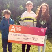 William Wood-Robertson and his siblings with a cheque for the charity