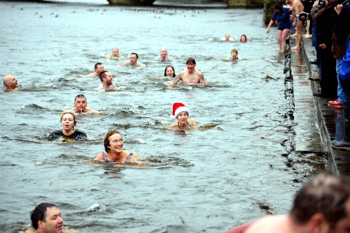 Swimmers – one in a Santa hat – making their way down the Wharfe