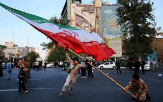 Demonstrators wave a huge Iranian flag in Tehran on April 15 (Vahid Salemi/AP)