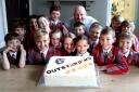 Ghyll Royd pupils gathered around the giant celebration cake to celebrate their inspection news, with headteacher David Martin