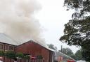 Pool Road has been closed as fire crews deal with a large building fire this afternoon