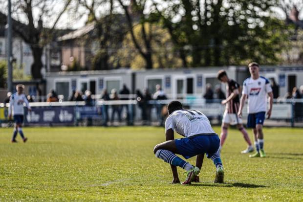 Guiseley players fall to their knees after relegation was confirmed on Saturday. Pic: Alex Daniel