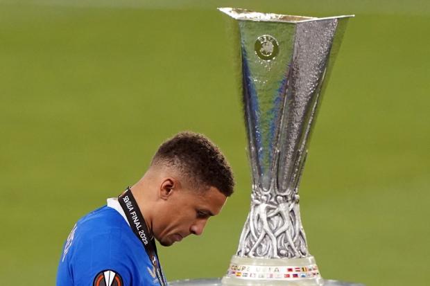 James Tavernier walks despondently past the Europa League trophy after Rangers lost last night's final on penalties. Picture: PA.
