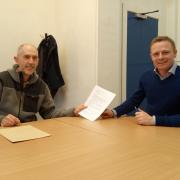 Mike Daw handing the letter to Robbie Moore at his constituency surgery