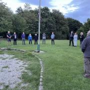 Curly Hill Camp Site team at the flagpole following a reflection for HM Queen Elizabeth II