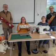 Mike Dennis, leader at Beech Hill Church, Andi Petch and Heather Knight of Otley sewing collective, Richard Hughes, Chair of Otley Town Council and Watson, the unofficial warm spaces dog with some of the draught excluders