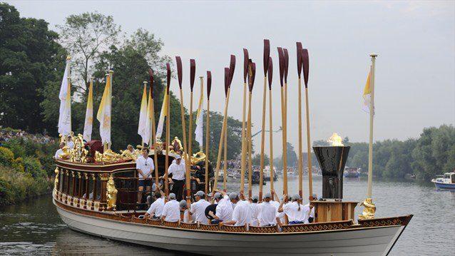 The Flame travels down the Thames on board the Royal barge Gloriana en route to the Olympic Stadium...