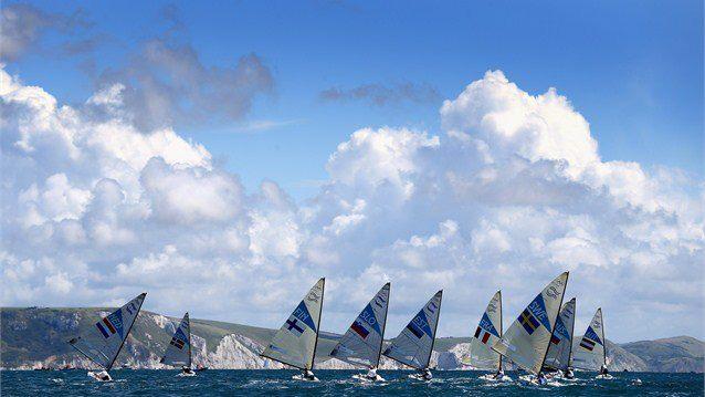 The Finn Class fleet head downwind during the first Finn Class race of the London 2012 Olympic Games at the Weymouth & Portland Venue at Weymouth Harbour... 