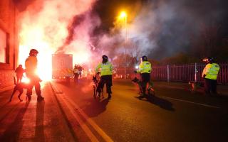 Police officers with dogs as flares are set off outside Villa Park (David davies/PA)